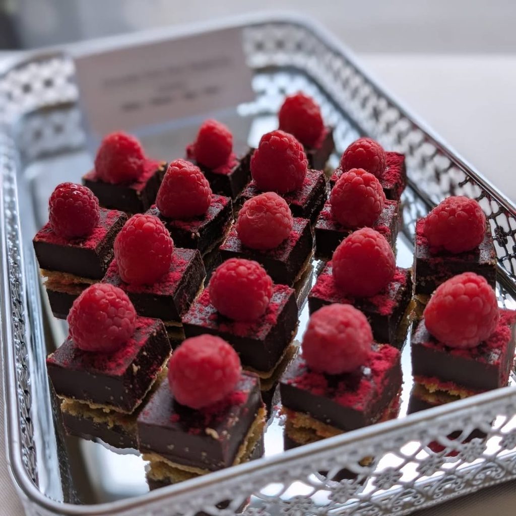 Chocolate and raspberry dessert bites displayed on a serving tray